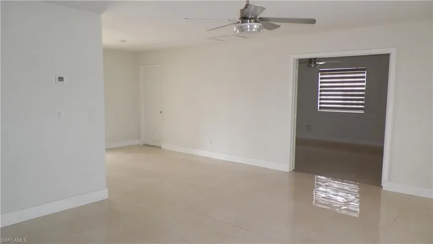 Unfurnished room featuring light tile patterned floors and ceiling fan