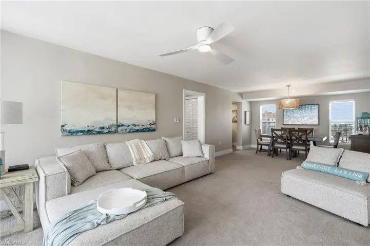 Open-concept living area with neutral wall color, recessed lighting, and a ceiling fan - Virtually Edited Image