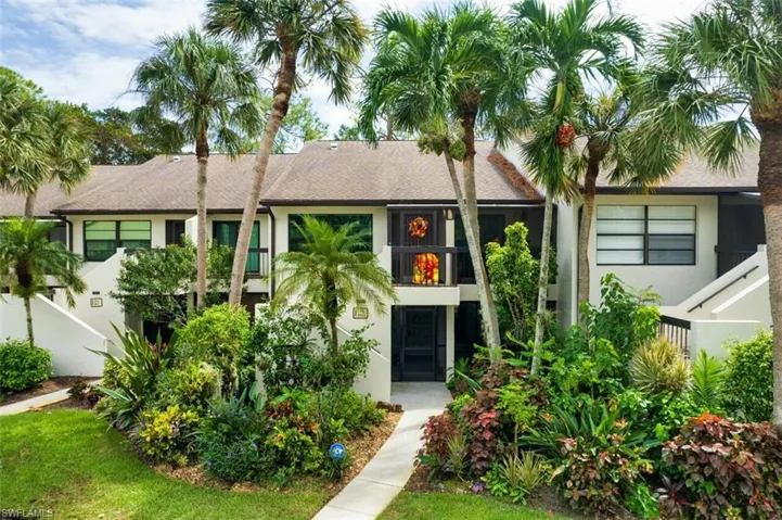 View of property featuring fence, a balcony, and stucco siding