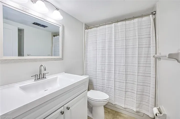 Full bath with vanity, toilet, and tile patterned floors