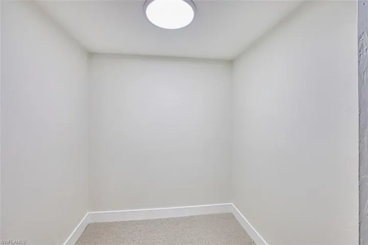 Spare room featuring carpet floors and baseboards