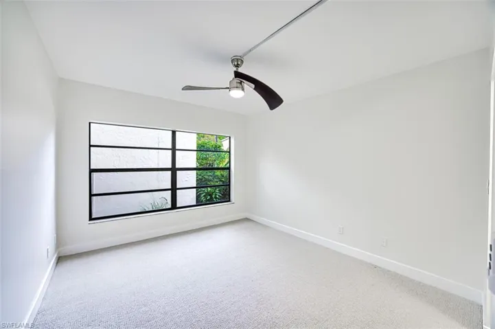 Empty room featuring ceiling fan, carpet flooring, and baseboards