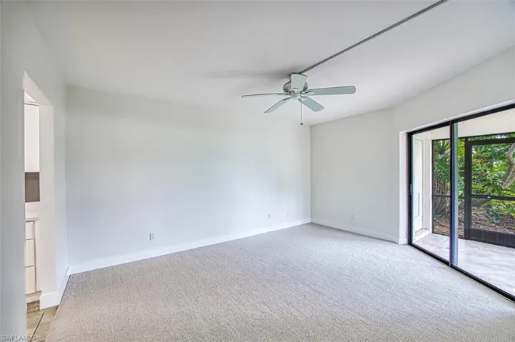 Spare room with a ceiling fan, light carpet, and baseboards