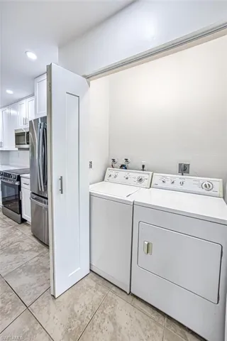 Clothes washing area with laundry area, recessed lighting, and independent washer and dryer