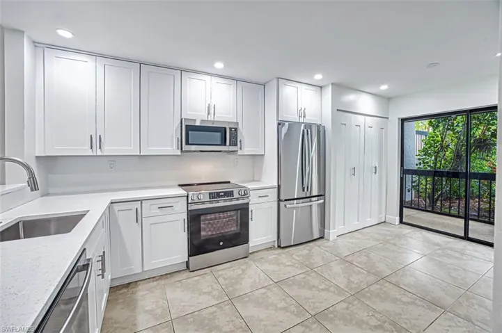 Kitchen featuring appliances with stainless steel finishes, recessed lighting, white cabinetry, and a sink