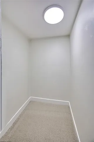 Spare room featuring carpet and baseboards