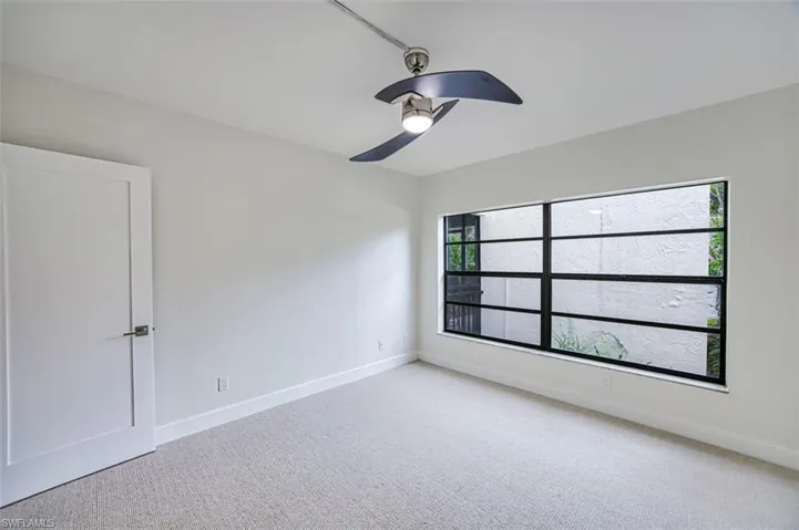 Spare room with ceiling fan, carpet floors, and baseboards