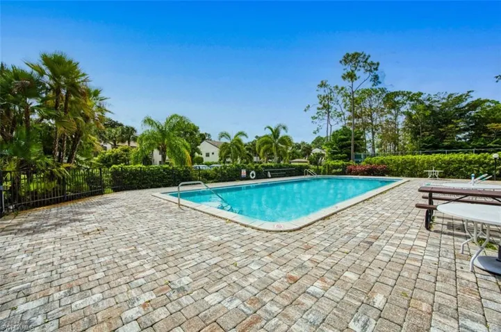 Pool with a patio and fence