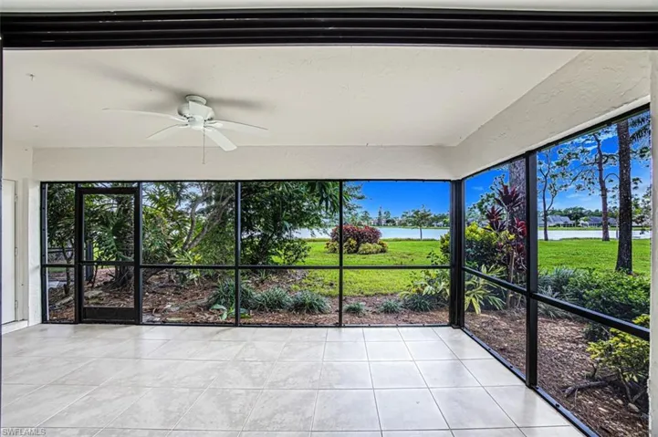 Unfurnished sunroom with a ceiling fan, a water view, and plenty of natural light