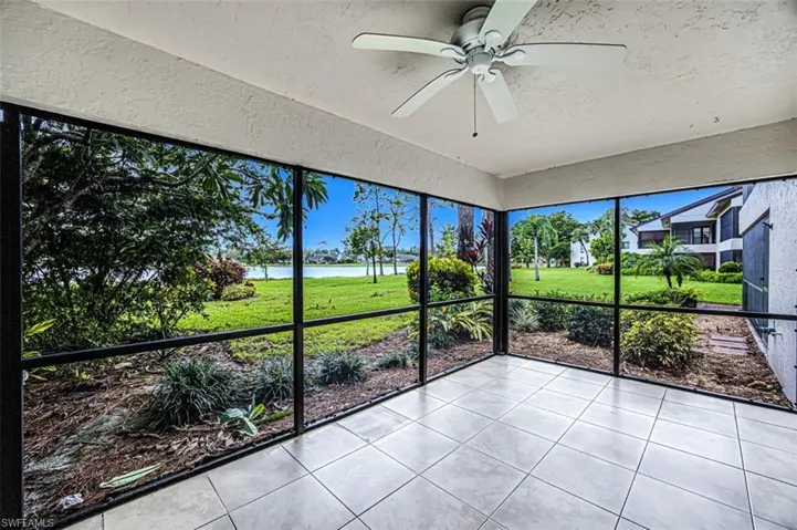 Unfurnished sunroom with a ceiling fan and a water view