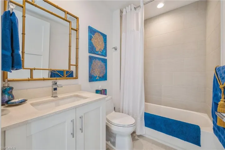 Full bathroom featuring toilet, vanity, and shower / tub combo with curtain