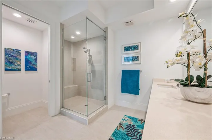 Bathroom with tile patterned floors, vanity, and a shower with door