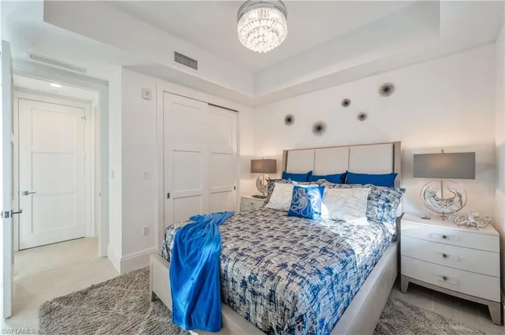 Bedroom featuring a raised ceiling, a closet, and a notable chandelier
