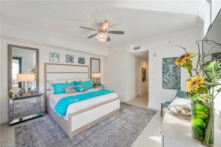 Bedroom with ceiling fan and ornamental molding