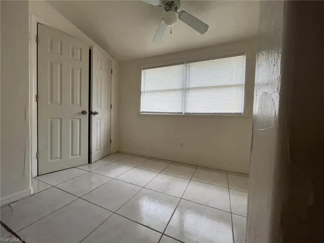 Unfurnished bedroom featuring light tile patterned floors, ceiling fan, and baseboards