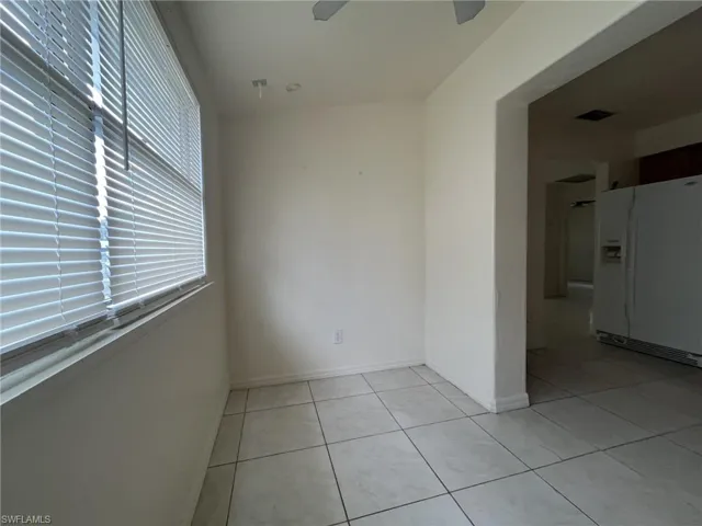 Unfurnished room featuring light tile patterned floors, visible vents, and baseboards
