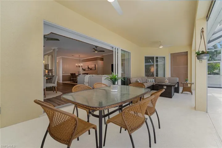 Dining room featuring ornamental molding, light wood-type flooring, and ceiling fan with notable chandelier