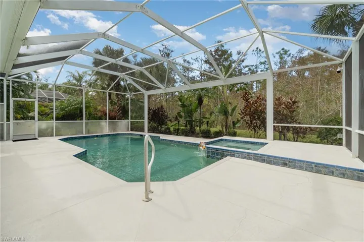 View of swimming pool featuring a patio, an in ground hot tub, and glass enclosure