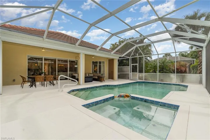 View of swimming pool with an in ground hot tub, a patio area, glass enclosure, and ceiling fan
