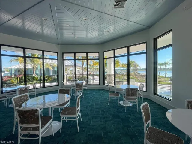 Sunroom / solarium with carpet flooring, a water view, wooden ceiling, and plenty of natural light
