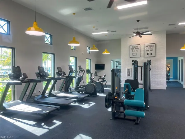 Exercise room featuring a high ceiling and ceiling fan