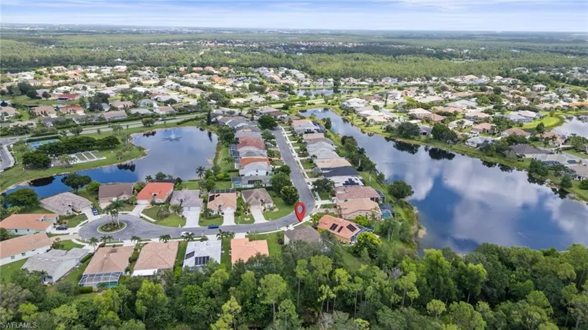 Aerial view of property and surrounding area with a large body of water and nearby suburban area