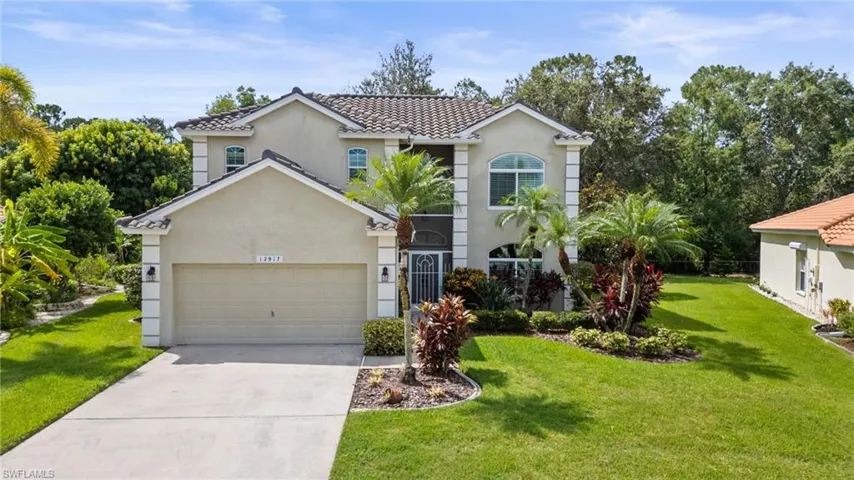 Mediterranean / spanish-style house featuring a front lawn, an attached garage, stucco siding, driveway, and a tile roof
