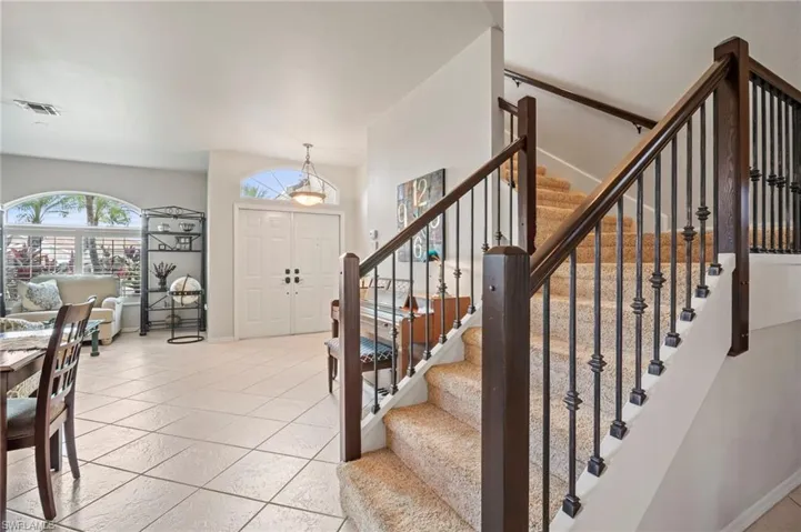 Foyer featuring stairway and light tile patterned floors