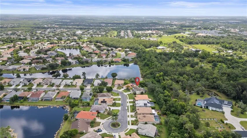 Aerial view of property and surrounding area with nearby suburban area and a nearby body of water