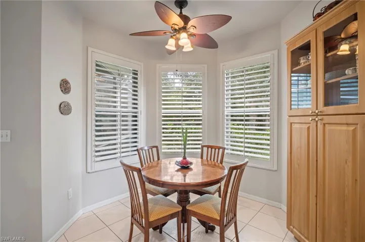 Dining area featuring light tile patterned flooring, healthy amount of natural light, and ceiling fan