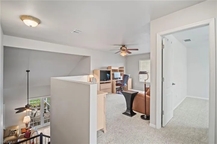 Loft featuring a desk and light colored carpet