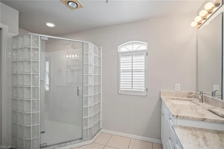 Full bathroom with vanity, light tile patterned floors, a stall shower, and recessed lighting