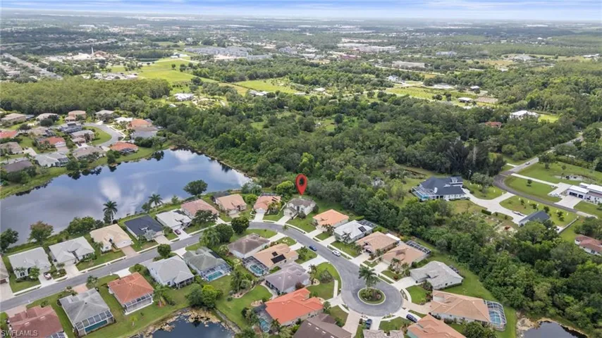 Aerial view of property and surrounding area with a large body of water and nearby suburban area