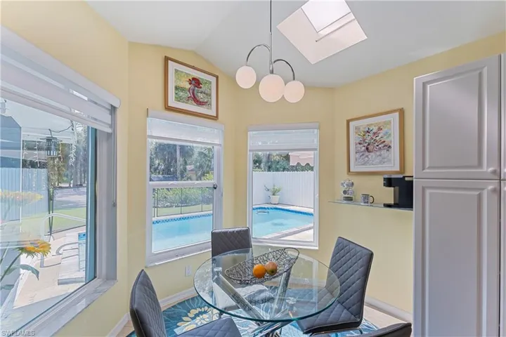Dining area with vaulted ceiling with skylight