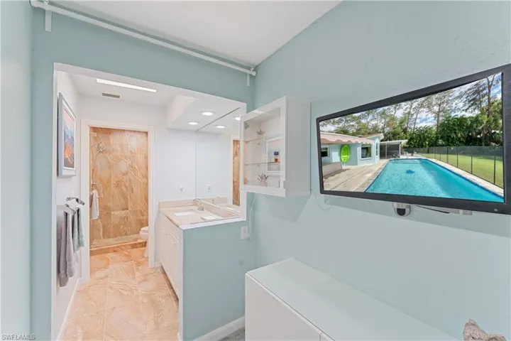 Bathroom featuring vanity, toilet, and a shower