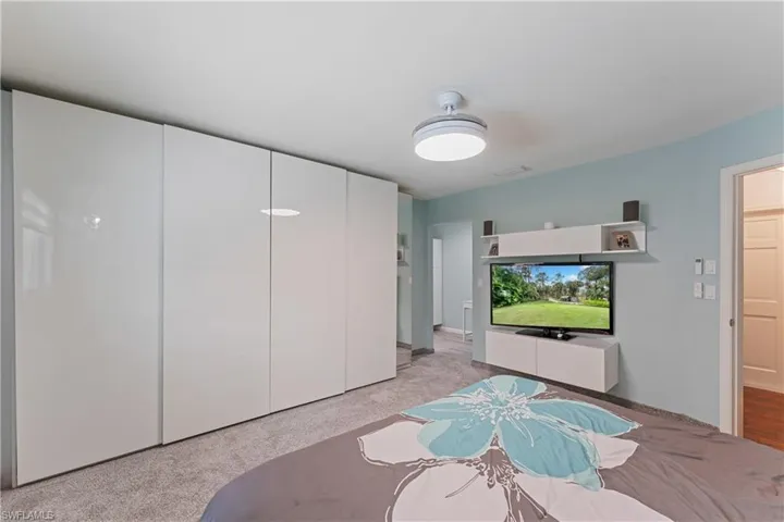Carpeted bedroom featuring a closet and ceiling fan