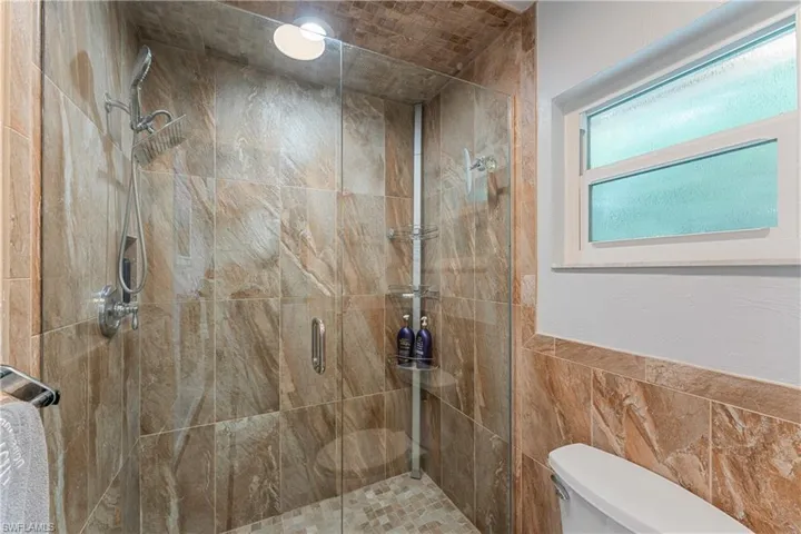 Bathroom featuring tile walls and walk in shower
