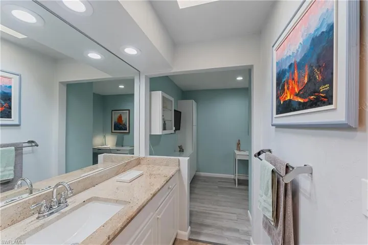 Bathroom with vanity, hardwood / wood-style floors, and a washtub