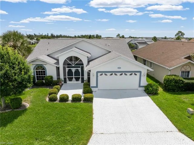 Single story home featuring an attached garage, decorative driveway, stucco siding, and a front yard