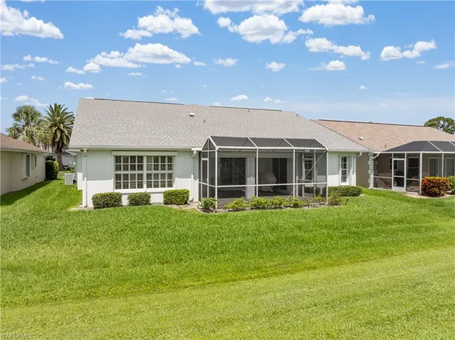 Back of property featuring a yard, a lanai, and stucco siding