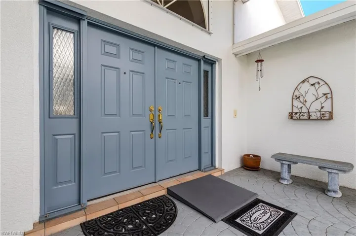 Doorway to property featuring stucco siding