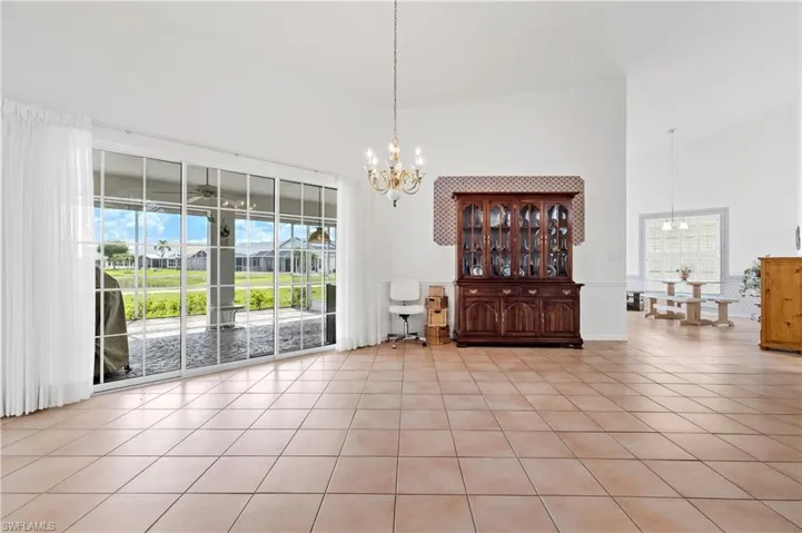 Dining space with a chandelier, a towering ceiling, and light tile patterned floors