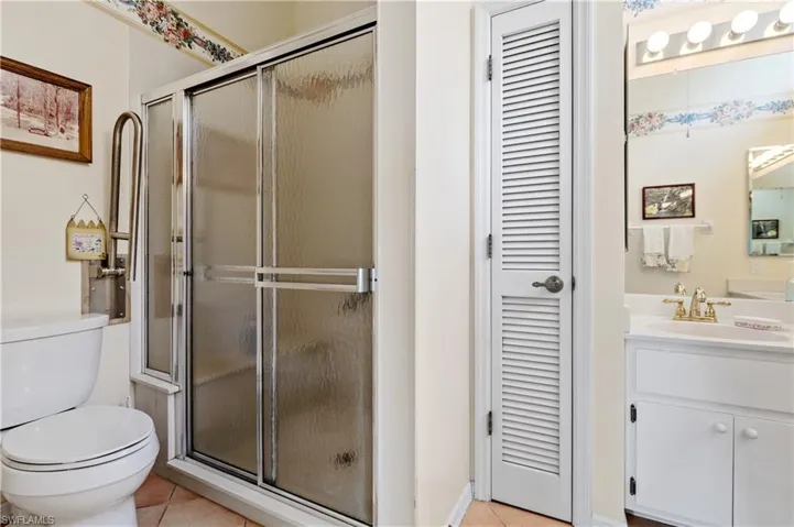 Full bathroom featuring a closet, tile patterned flooring, vanity, and a stall shower