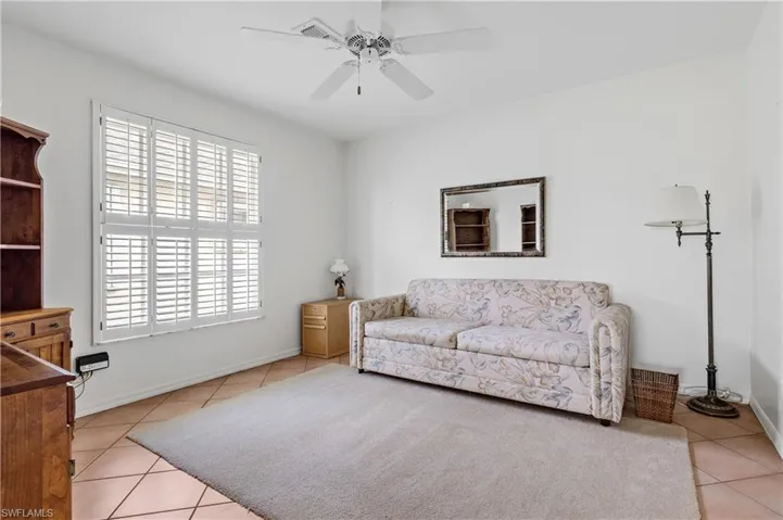 Living room featuring light tile patterned flooring and ceiling fan