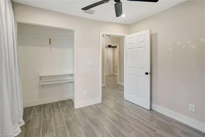 Unfurnished bedroom featuring ceiling fan, wood tiled floors, a closet, and recessed lighting