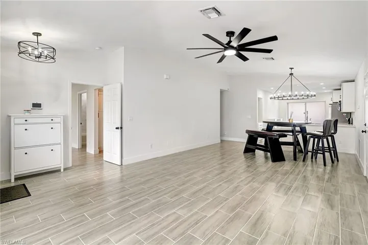 Dining space featuring a chandelier, wood finish floors, and a ceiling fan