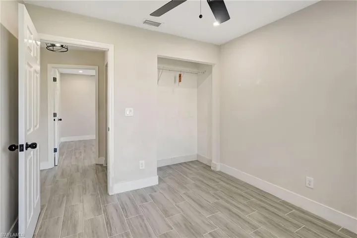 Unfurnished bedroom featuring a closet, recessed lighting, a ceiling fan, and wood finish floors