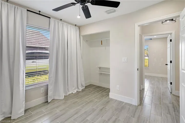 Unfurnished bedroom featuring ceiling fan, wood tiled floors, and a closet