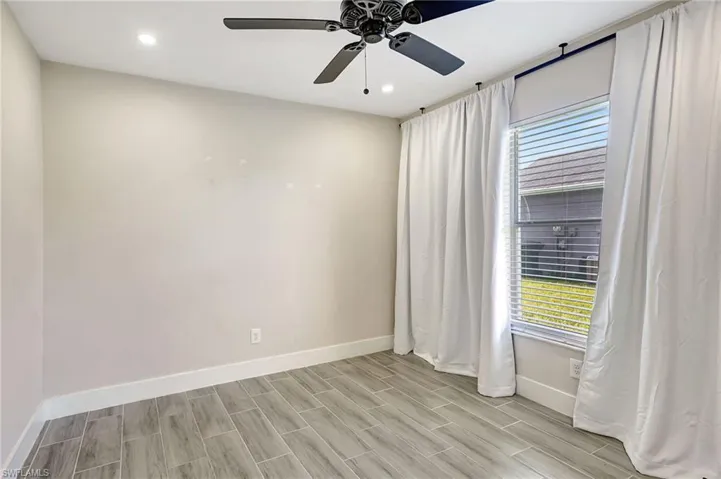 Spare room with a ceiling fan, recessed lighting, and wood finish floors