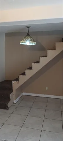 Stairway with carpet patterned floors and baseboards